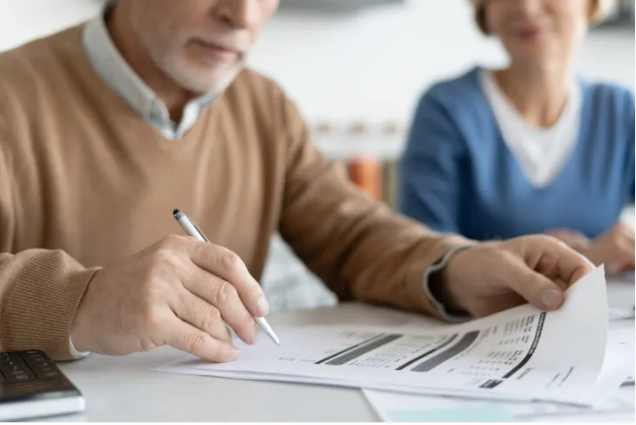 Un couple étudie des documents patrimoniaux avec son notaire